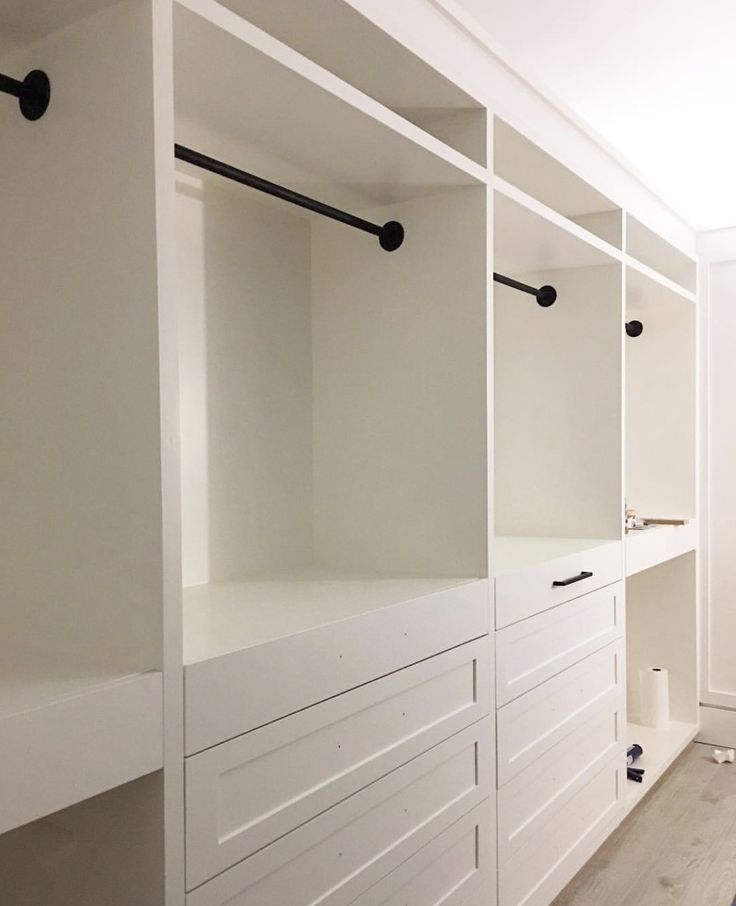 an empty room with white cabinets and drawers