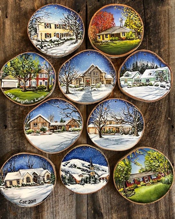 six christmas plates on a wooden table with houses in the snow and trees painted on them