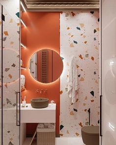 a bathroom with orange and white wallpaper and a round mirror on the wall above the sink