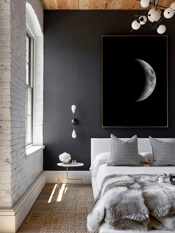 the bedroom is decorated in black and white with a full moon painting on the wall