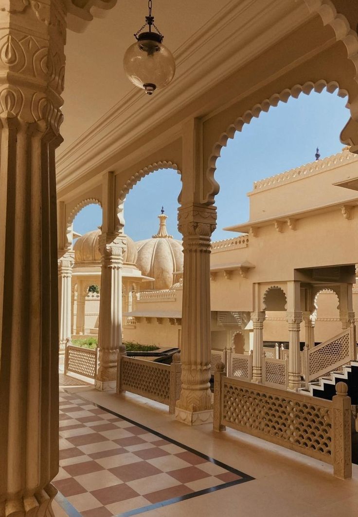 the inside of a building with columns, arches and checkered flooring in front of it