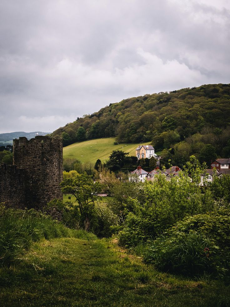 an old castle sitting on top of a lush green hillside