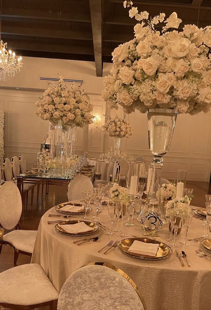 a table set with white flowers and place settings for an elegant dinner party or reception