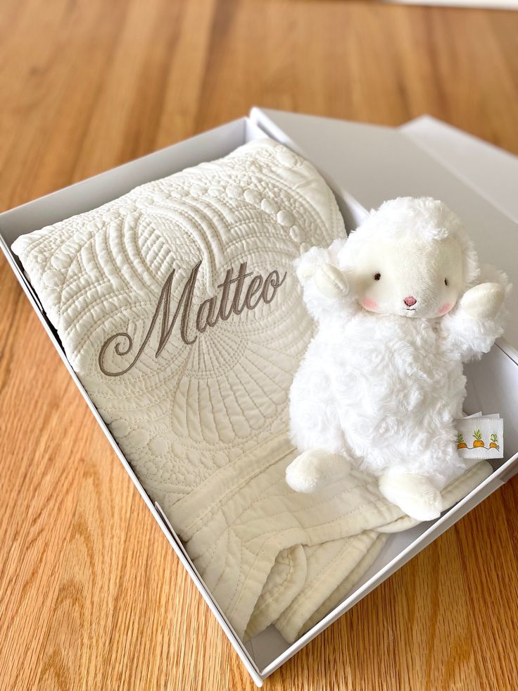 a white stuffed animal in a box on a wooden floor with the word matro written on it