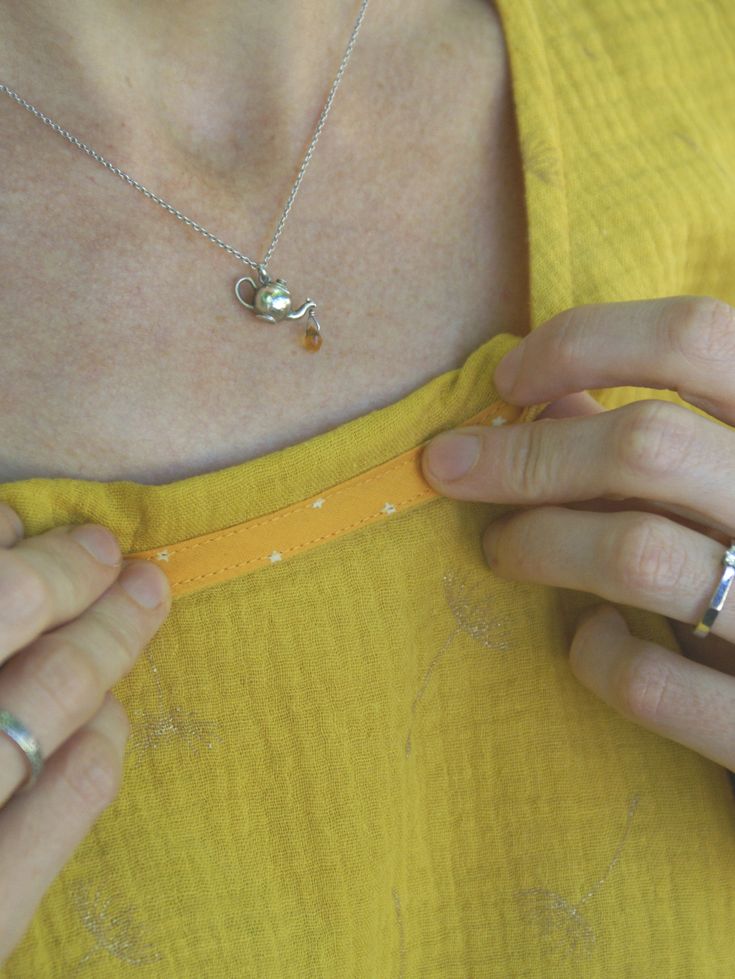 a woman wearing a yellow shirt is holding onto her ring