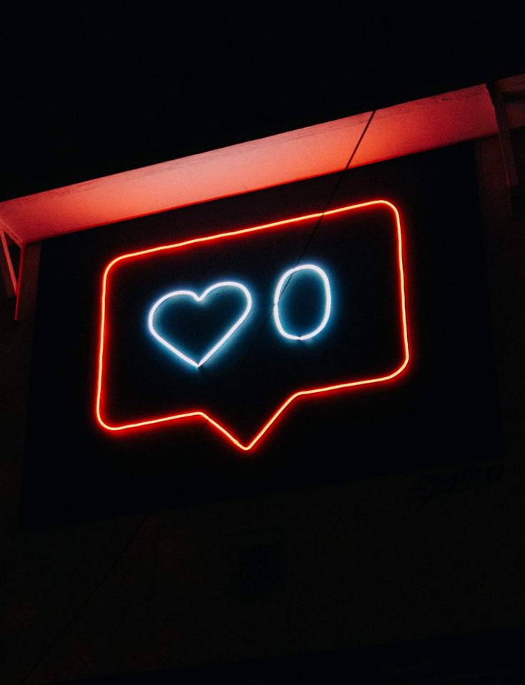 a neon sign with two hearts in the shape of speech bubbles on it's side