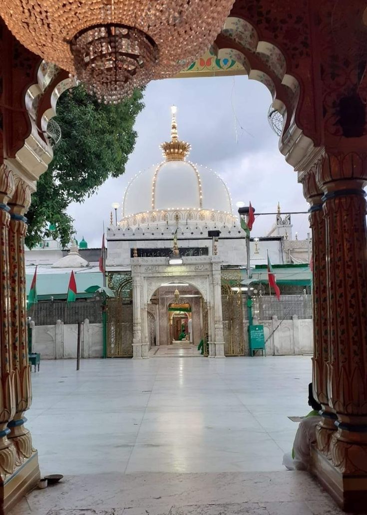 an archway leading to a white building with a golden dome on it's roof