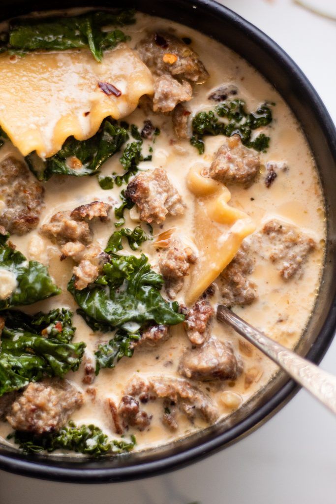 a skillet filled with cheese and spinach covered in meat, broccoli