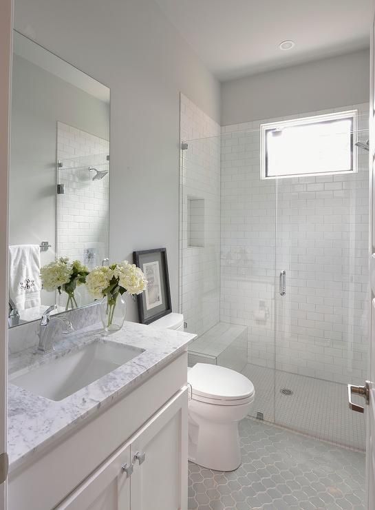 a bathroom with a sink, toilet and shower stall in the middle of it is shown