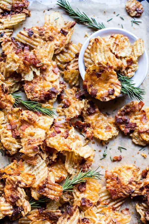 baked potato chips on a baking sheet with rosemary sprigs