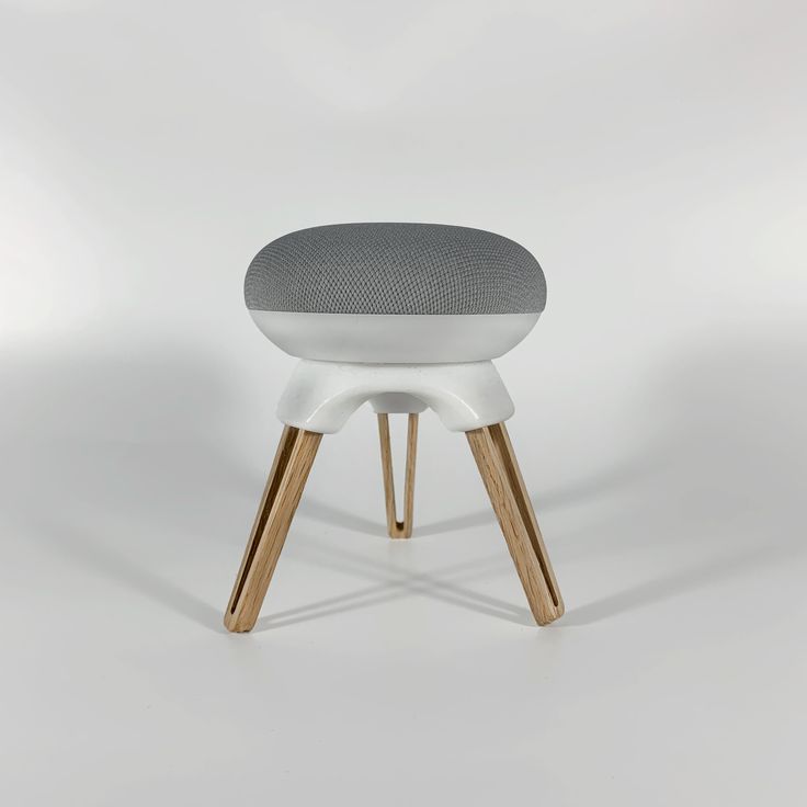 a white stool with wooden legs and a grey cushion on it's backrest