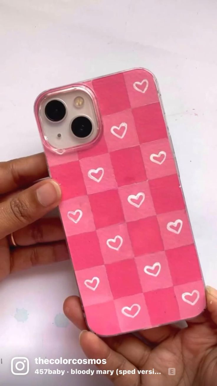 someone is holding up their pink iphone case with hearts on the front and back side