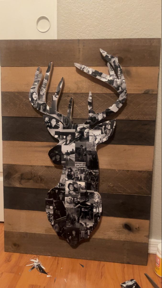 a deer head made out of wood with photos on the antlers and black and white stripes