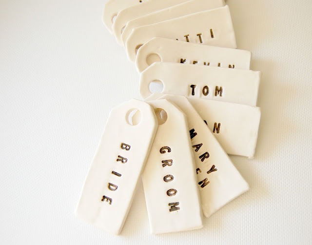 six ceramic tags with words on them