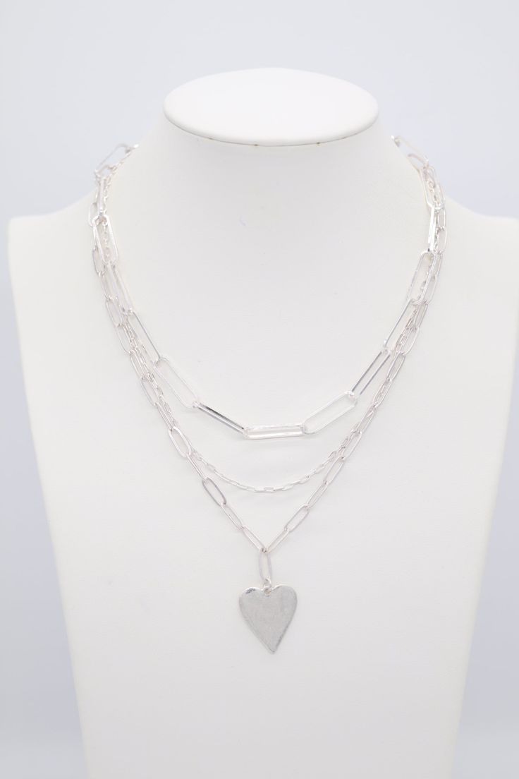 This necklace is a fun accessory to wear every day! It's a silver chain with a heart charm. The heart charm is a great way to add a little bit of romance to your outfit. Silver Layered Heart Necklace For Gifts, Silver Heart-shaped Layered Necklace As A Gift, Silver Heart-shaped Layered Necklace For Gifts, Silver Heart-shaped Layered Necklace Gift, Metal Charm Necklace With Heart Pendant And Silver Chain, Trendy Silver Charm Necklace With Heart Charm, Trendy Double Heart Charm Necklace, Trendy Silver Charm Necklace For Valentine's Day, Silver Charm Necklace For Valentine's Day