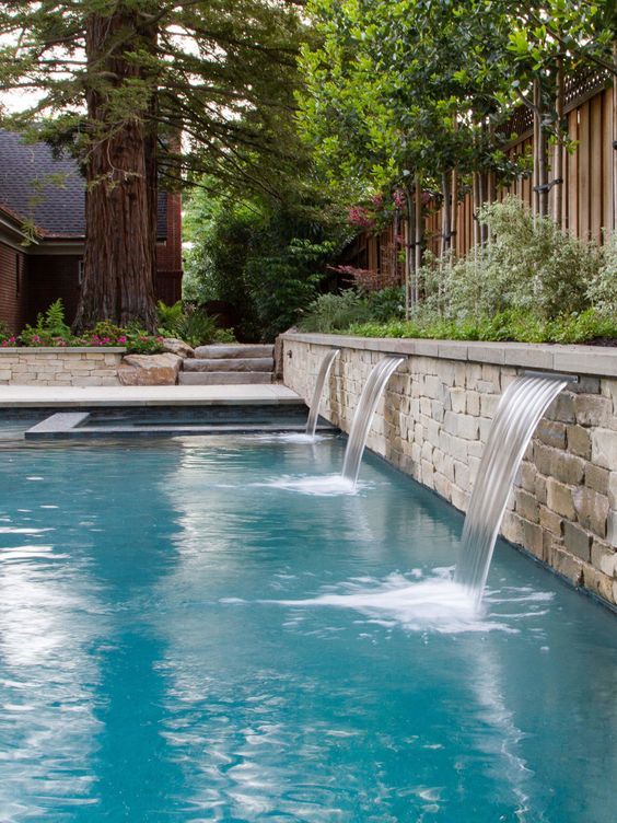 an outdoor swimming pool with water running from it