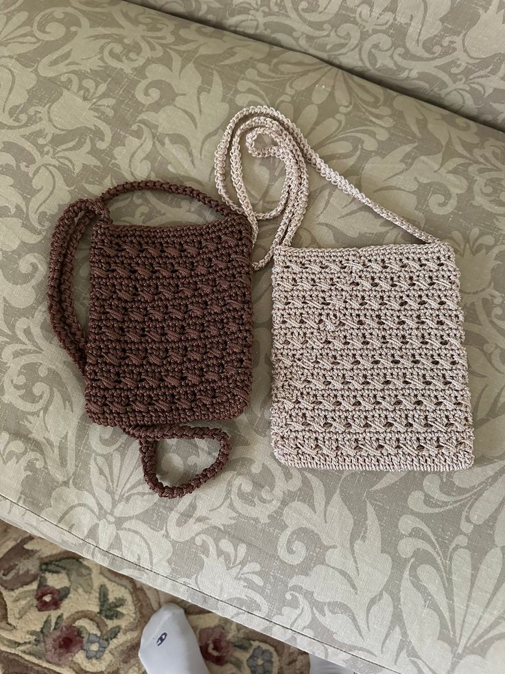 two crocheted purses sitting on top of a couch next to each other