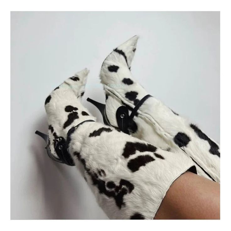 a pair of white and black dalmatian print gloves on someone's legs