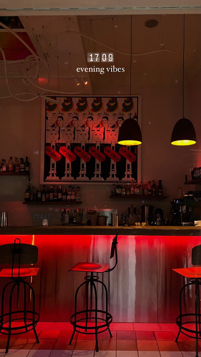 two bar stools in front of a counter with red lights on it and an advertisement above the bar