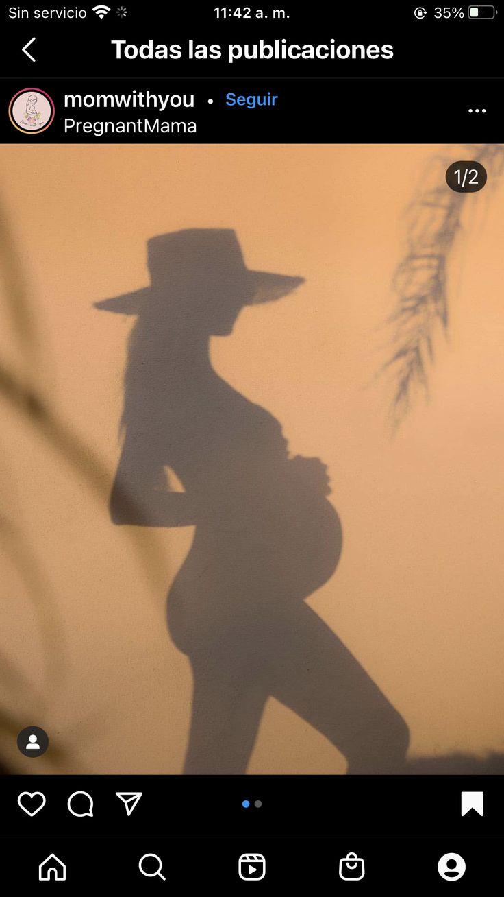 the shadow of a person wearing a hat and holding a baby in her arms is seen on an instagram