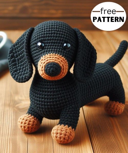 a crocheted black dog sitting on top of a wooden table