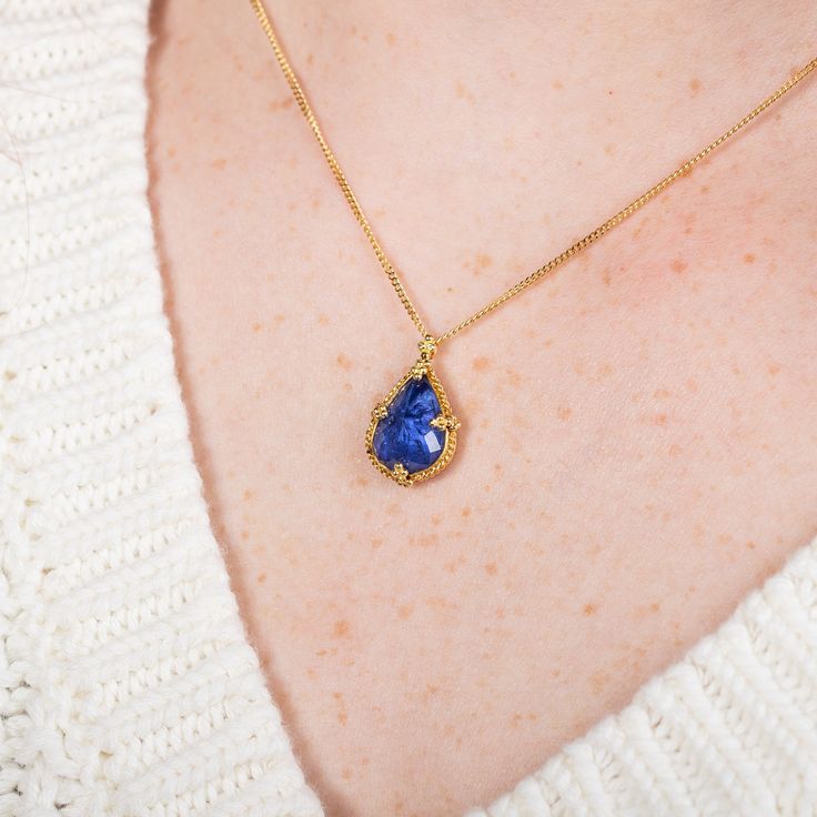 This luminous teardrop Tanzanite glows with a powerful blue hue; a vibrant, regal color that glows and shifts when its faceted surface catches the light. This captivating gemstone is set in a handmade gold setting accented with braided gold. It’s strung on an 18k yellow gold chain. One of a kind. Technical Details Metal: 18k yellow goldTanzanite: 5.57 cts. Pendant Size (not including bail): 16 x 12.5mmChain: can be worn at 16" and 18"Closure: lobster claspHandmade in New YorkStyle # N-3398-TA Sapphire Teardrop Jewelry With Gemstone Accents, Tanzanite Teardrop Gemstone Jewelry, Teardrop Tanzanite Gemstone Jewelry, Blue Tanzanite Teardrop Jewelry, Teardrop Tanzanite Jewelry In Yellow Gold, Handmade Yellow Gold Pear-shaped Jewelry, Handmade Pear-shaped Yellow Gold Jewelry, Gold Tanzanite Teardrop Jewelry, Gold Teardrop Sapphire Necklace