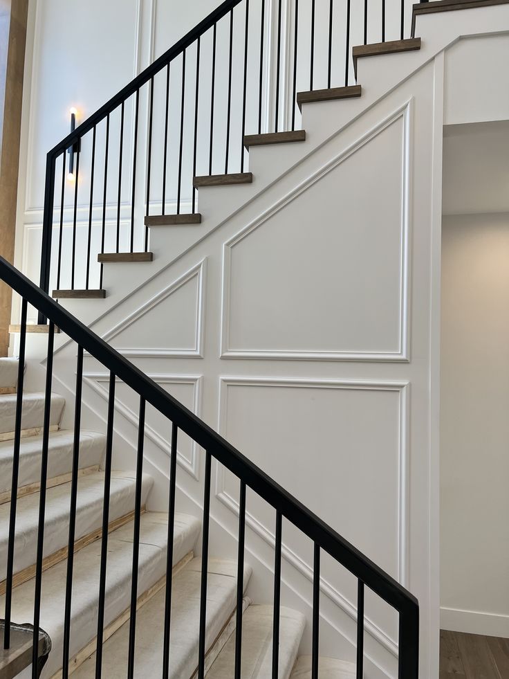 a staircase with white walls and black railings