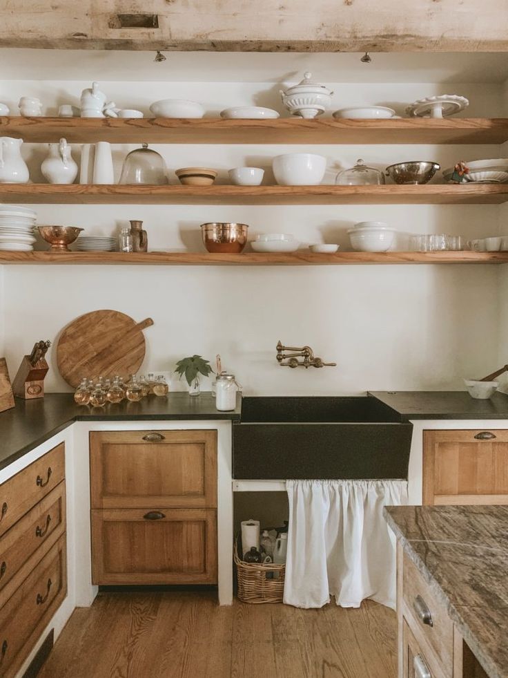 a kitchen with wooden cabinets and shelves filled with dishes