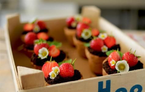 there are cupcakes with strawberries and flowers in the box