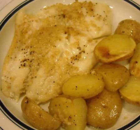 a white plate topped with fish and potatoes