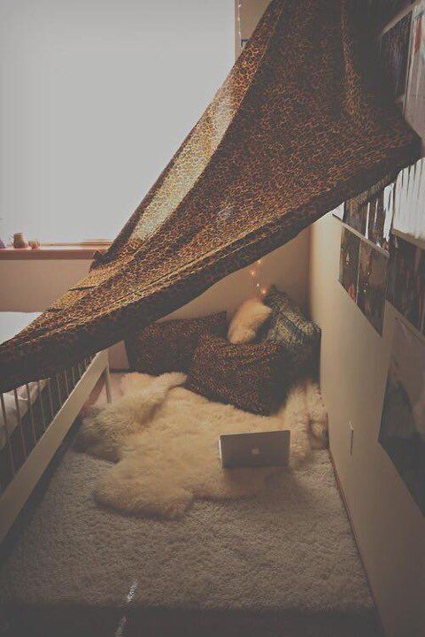 a bed with a canopy over it next to a window and rugs on the floor