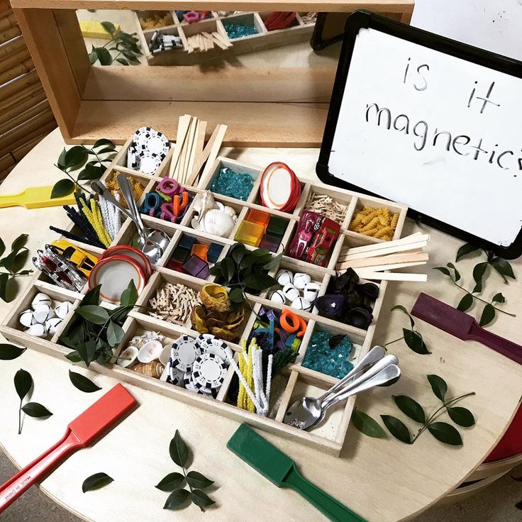 a wooden box filled with lots of crafting supplies on top of a white table