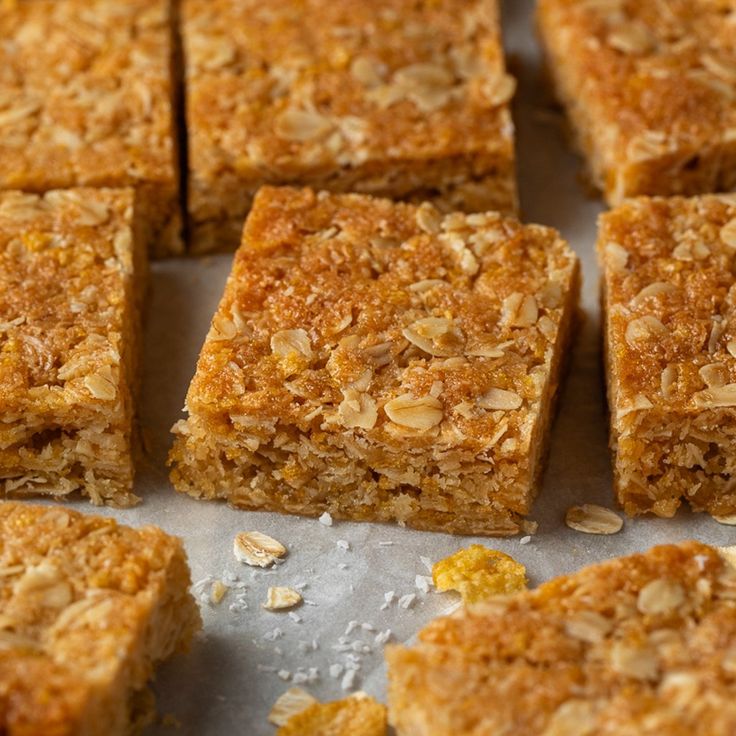 several squares of food sitting on top of a pan covered in granola toppings