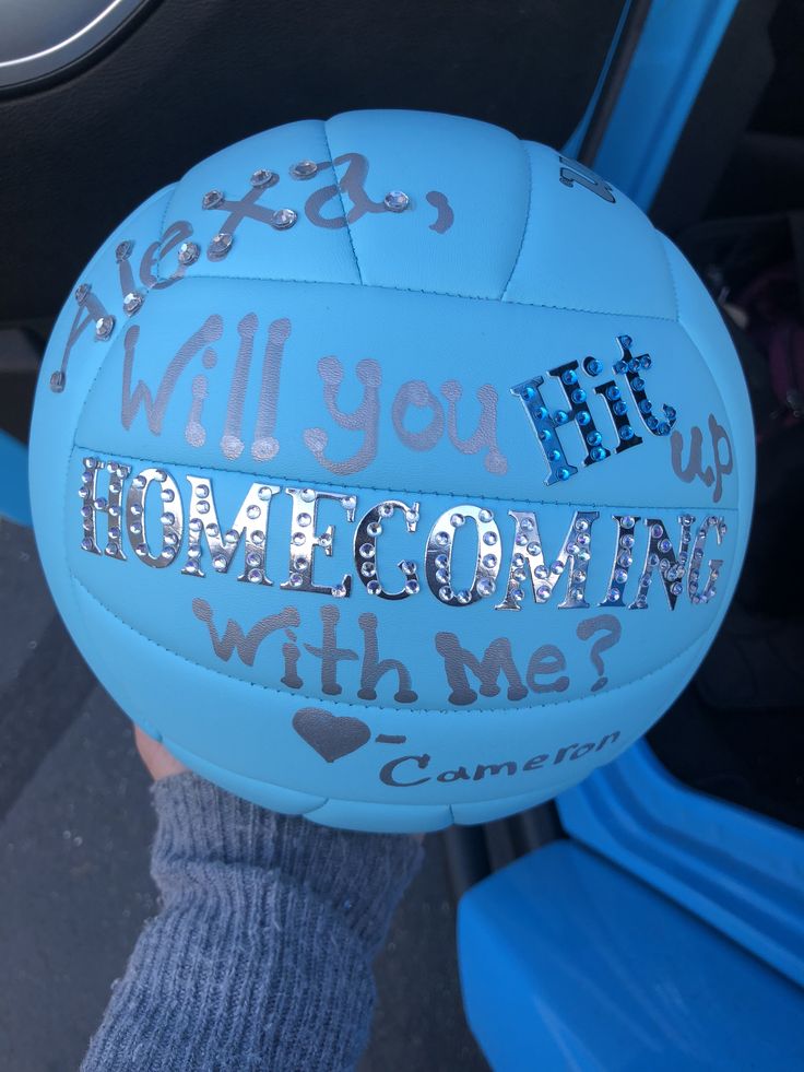 someone holding up a blue volleyball with writing on it that says, will you hit homeownin whine?