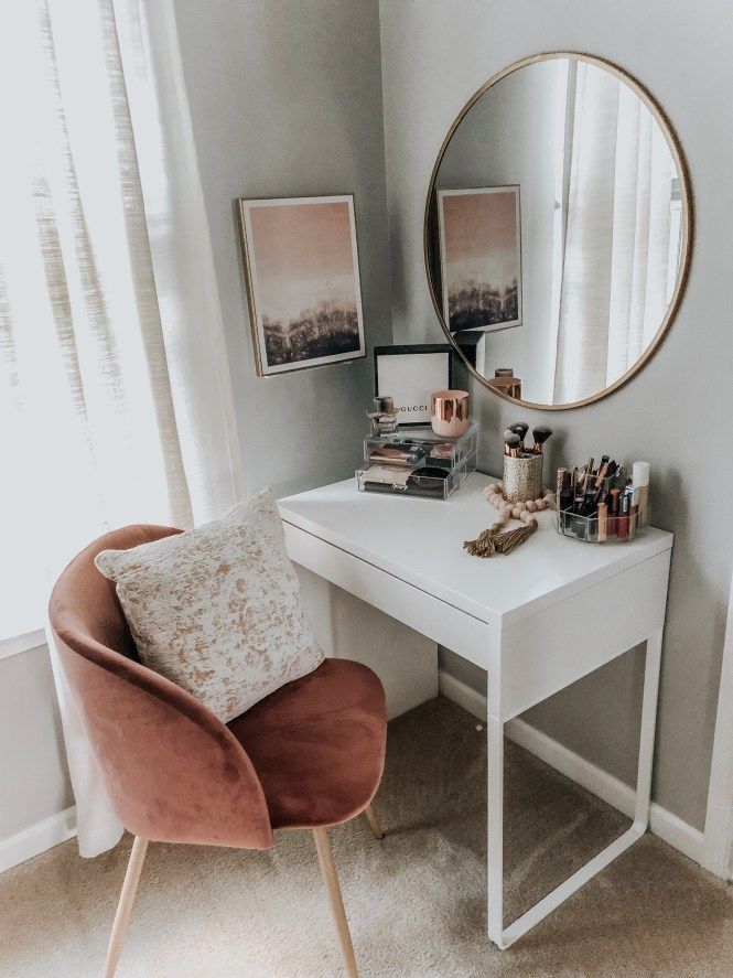 a white desk topped with a mirror and a chair