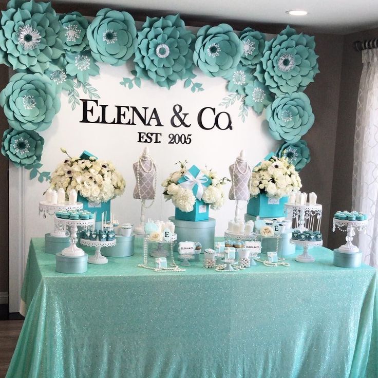 a table topped with blue and white flowers next to a sign that says elena & co