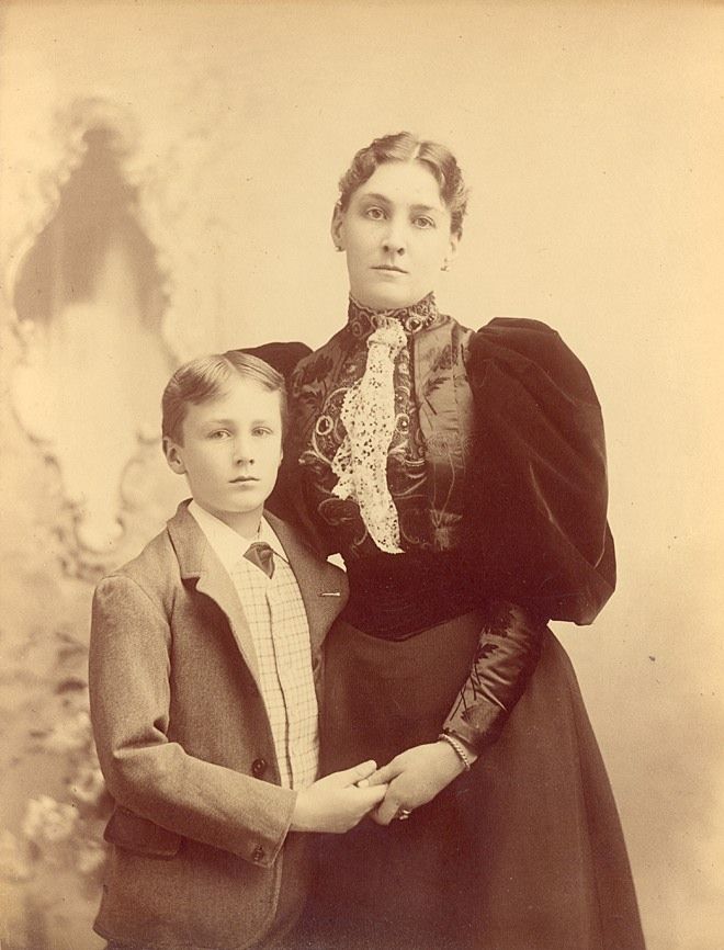 an old photo of two people standing next to each other