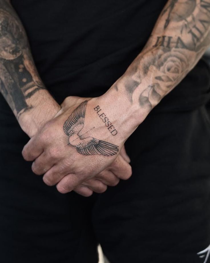 a man with tattoos holding his hands together