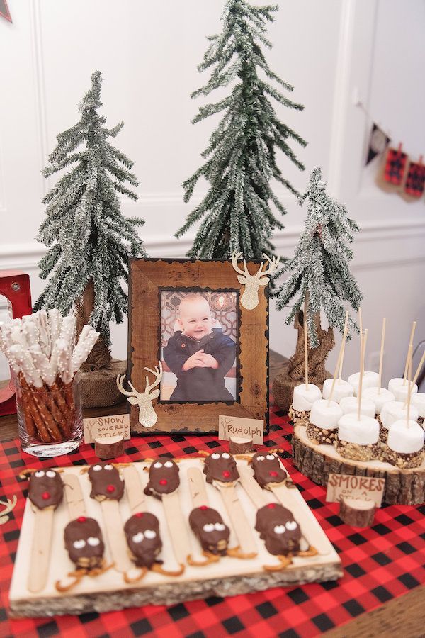 a table topped with cookies and pretzels next to trees