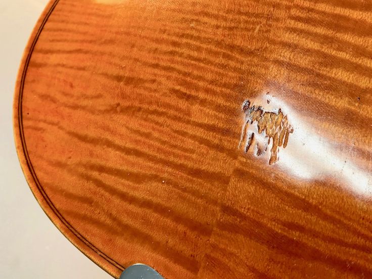 a close up of a wooden table with some writing on the top and an animal drawn on it