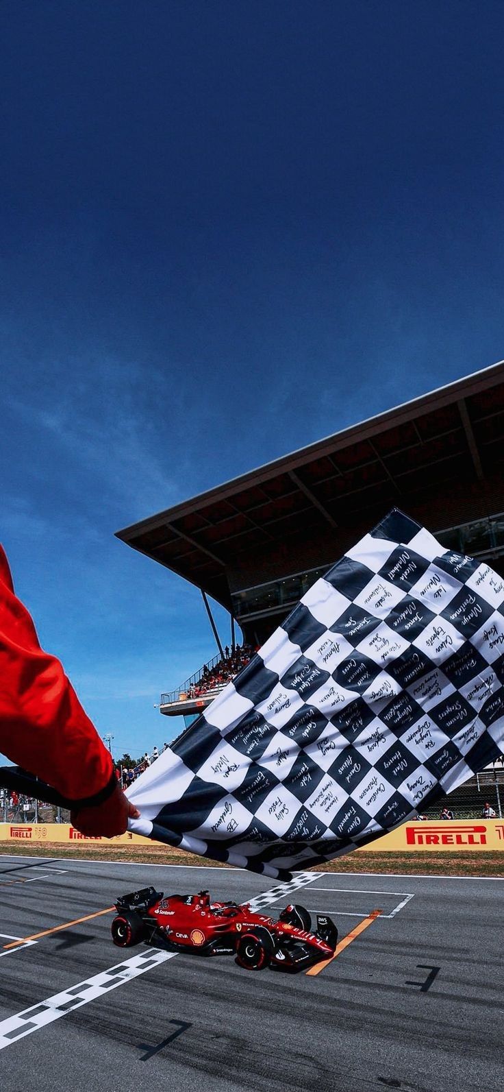 a man in red jacket standing next to a race car