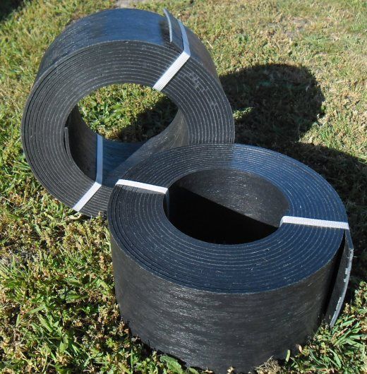 two rolls of black tape sitting in the grass