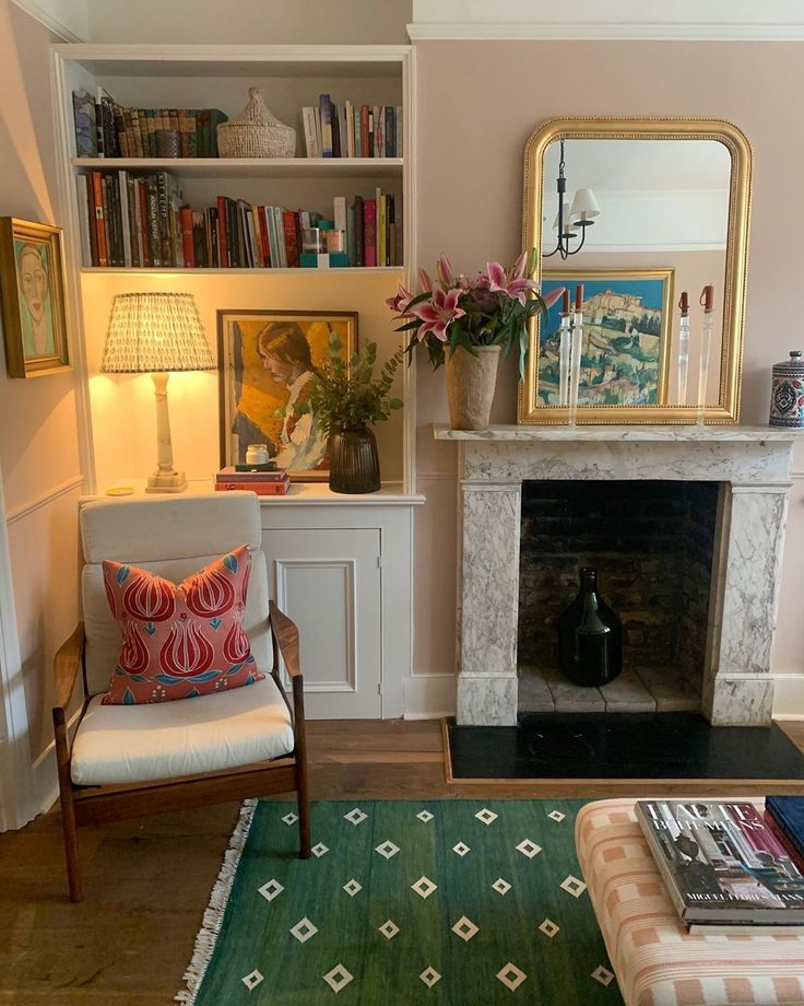 a living room filled with furniture and a fire place under a mirror on the wall