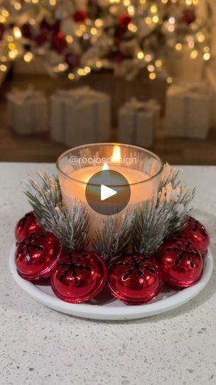 a white plate topped with red ornaments and a candle