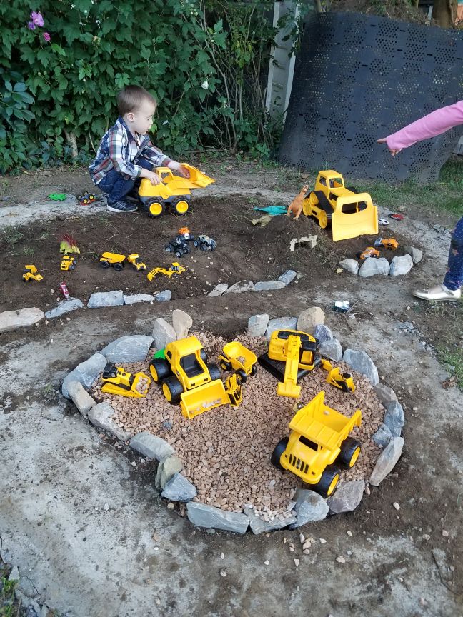 two children playing with toys in the dirt