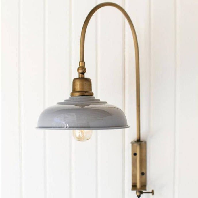 a lamp that is on the wall next to a light fixture with a white background