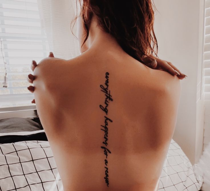 the back of a woman's body with writing on her upper and lower back