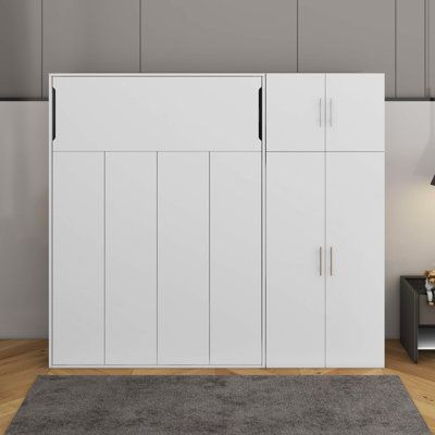 a living room with white cupboards and a gray rug in front of the wall