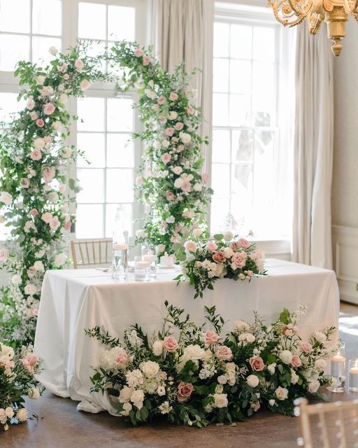 the table is covered with flowers and greenery