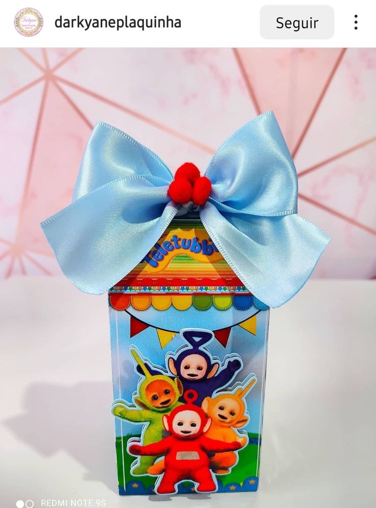 a small box with a blue bow on the top and an image of some cartoon characters in it